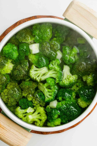 overhead photo of a bowl of bright green broccoli florets that have been blanched