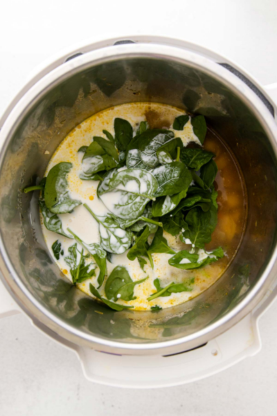 adding spinach and cream to instant pot bowl