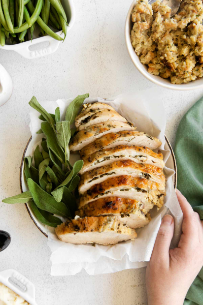 hand holding plate of turkey breast in instant pot