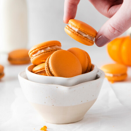 Photo of bright orange Pumpkin Spice Macarons made with almond flour and pumpkin spiced creamy filling in a bowl