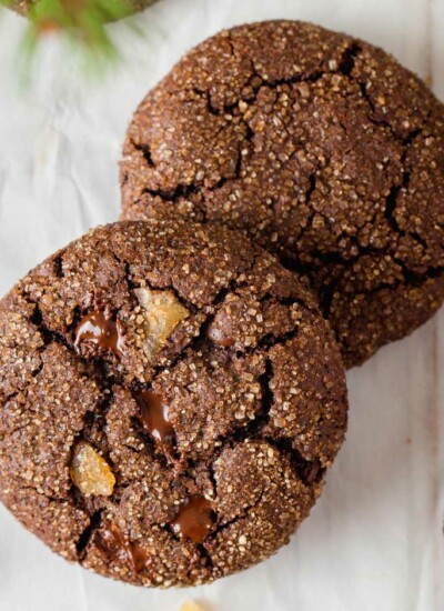 two chocolate gingerbread cookies on white parchment paper