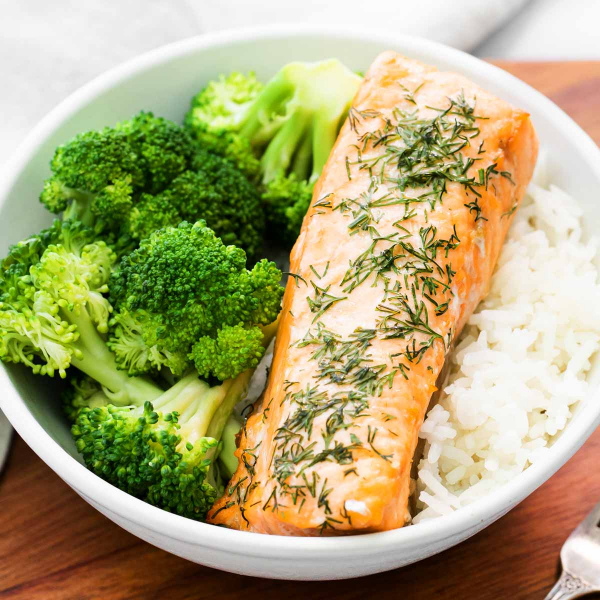 close-up of a bowl with filet of air fryer salmon and broccoli and rice