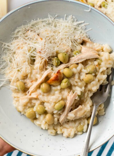 Image of a bowl of creamy chicken and pea risotto garnished with grated parmesan cheese