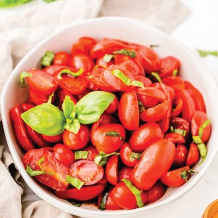 Sliced cherry tomatoes in bowl.