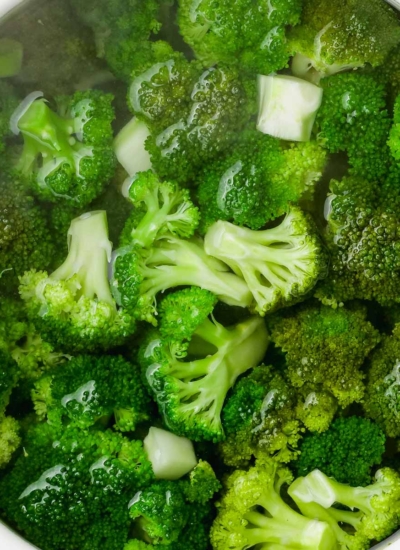 close-up of bright green boiled broccoli after perfectly cooked in a white bowl