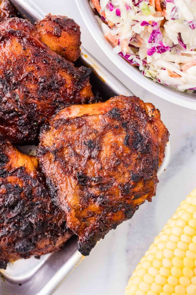 barbequed chicken thighs on a white serving dish