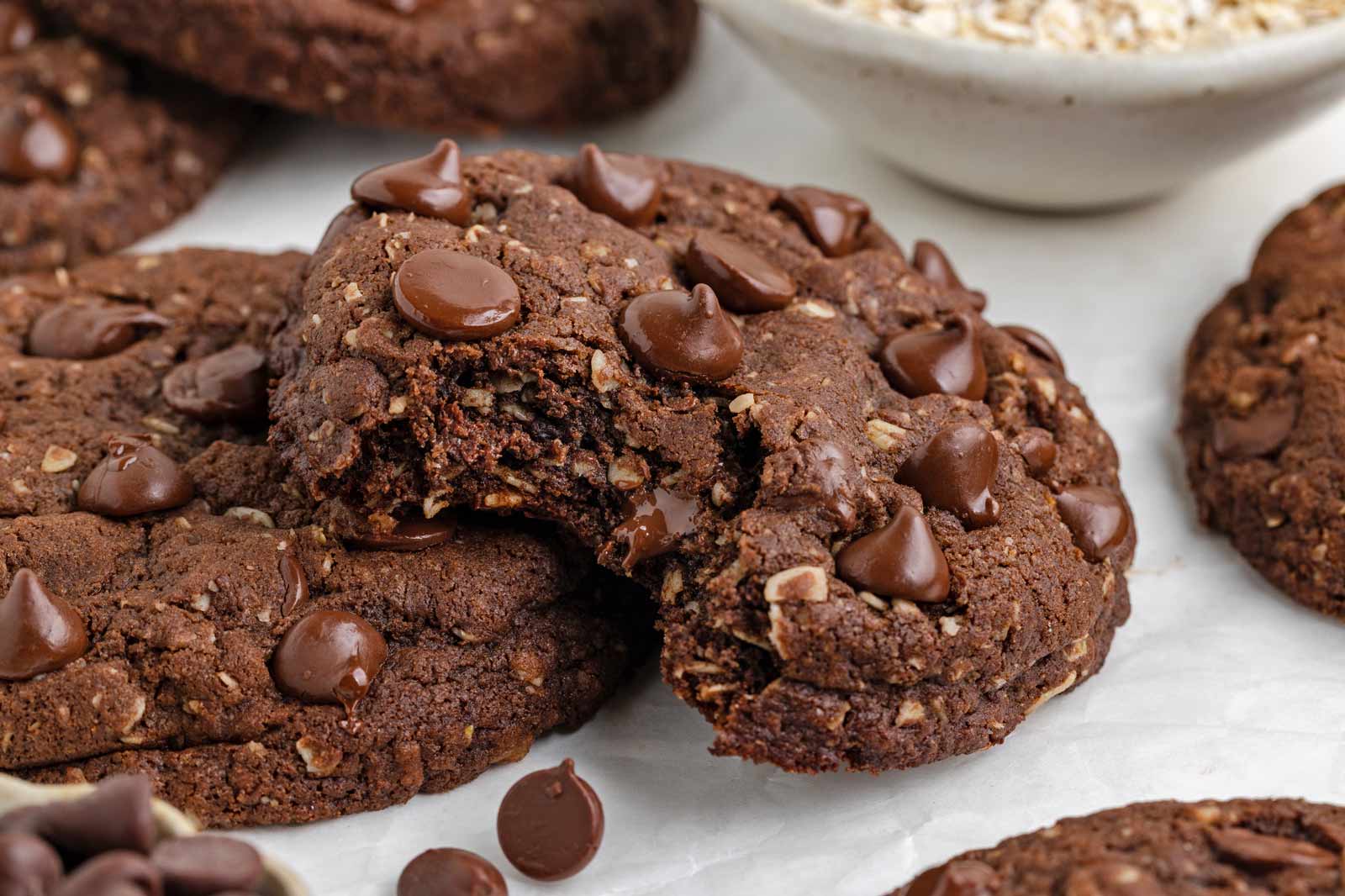 bit into cocoa oatmeal cookie on a white piece of parchment paper