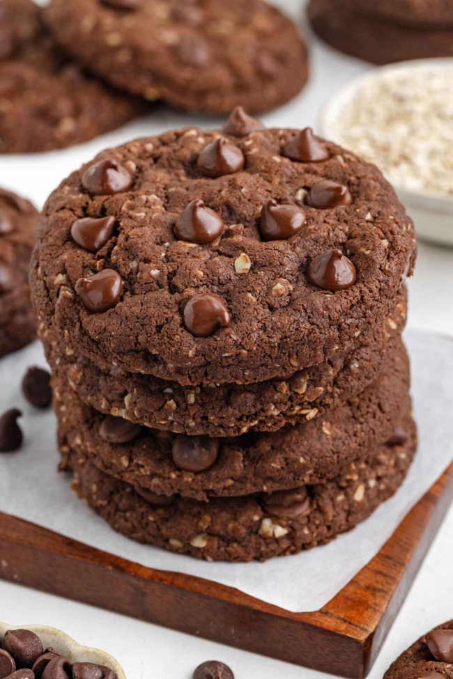 close-up of a stack of cocoa oatmeal cookies on a white table with more cookies in background