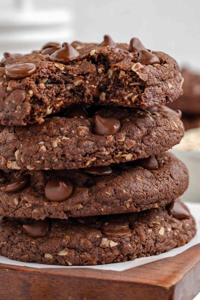 stack of 4 oatmeal cocoa cookies with a bite taken out of the top cookie