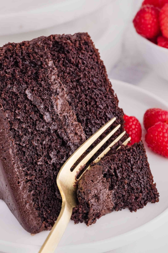 fork digging into a slice of dark cocoa cake