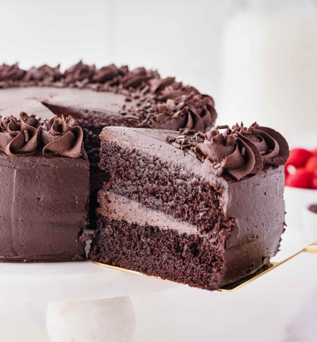 slice of dark cocoa cake being lifted with a cake server