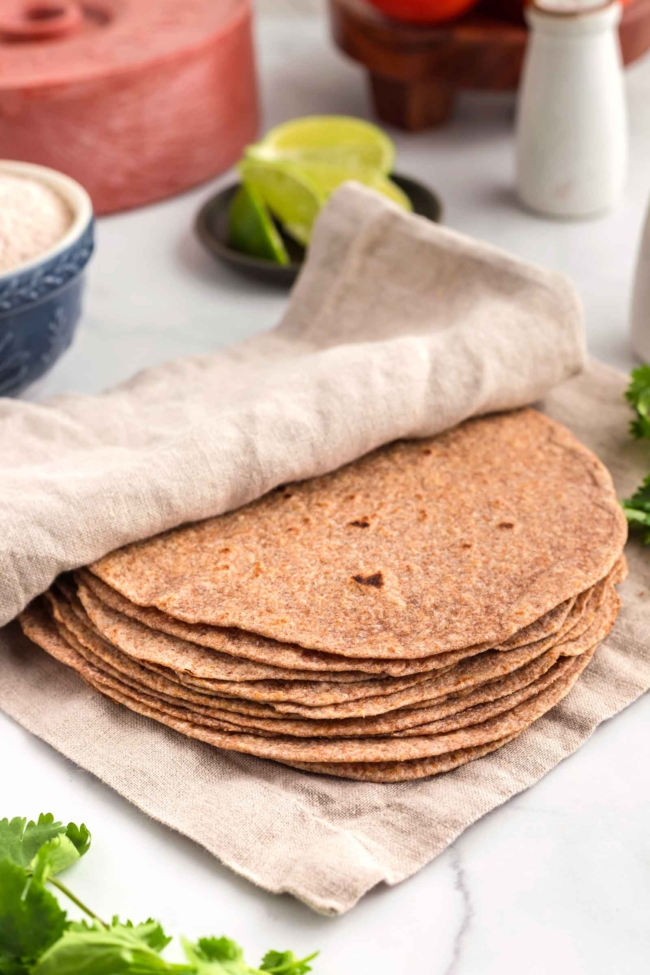 tortillas wrapped in a beige cloth on a white table