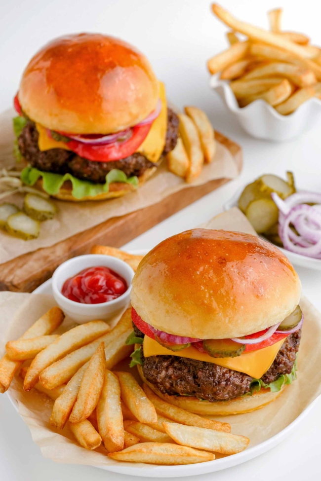 air fryer hamburgers on white plates with fries on the side