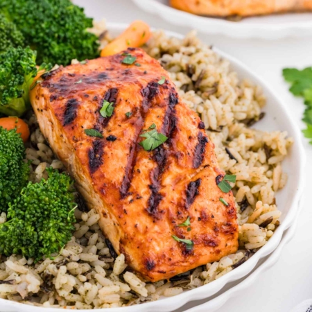 grilled salmon on a plate with wild rice and broccoli