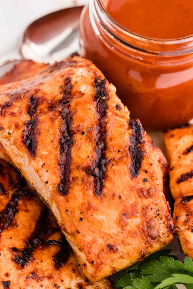BBQ sauce and barbequed salmon on a white plate
