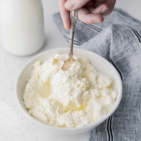 spoon digging into a bowl of ricotta cheese