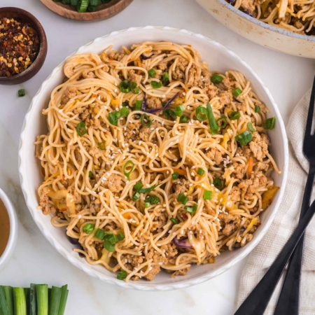 honey garlic noodles in a white bowl on a white table