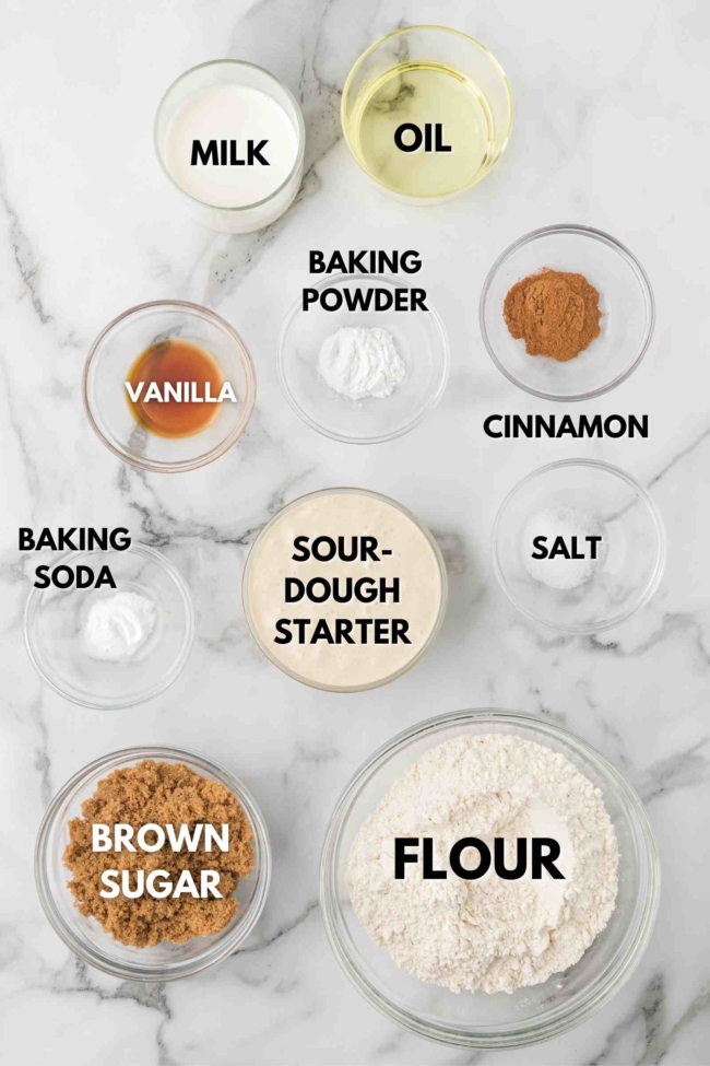 ingredients laid out to make sourdough cinnamon muffins on a white table