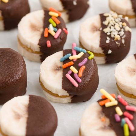 close-up of peanut butter bananas on white parchment paper