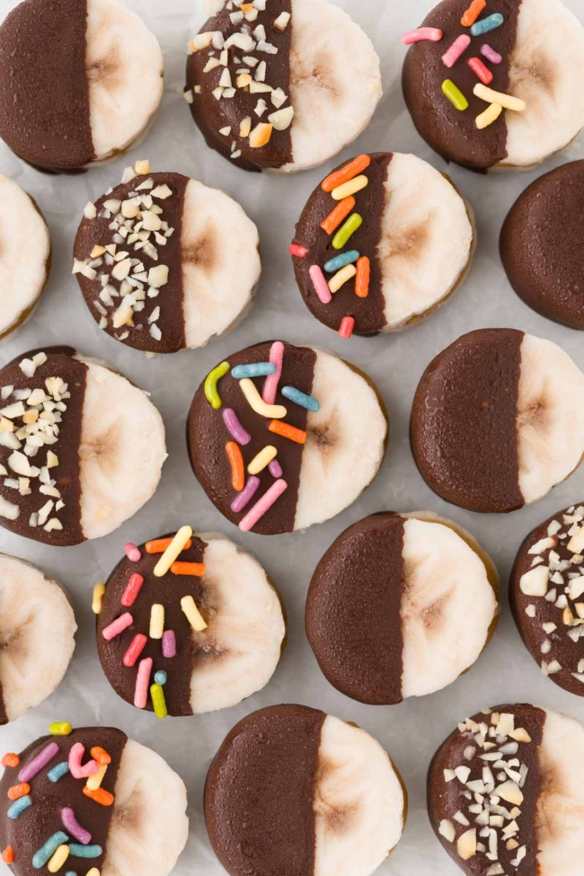 peanut butter bananas lined up on parchment paper