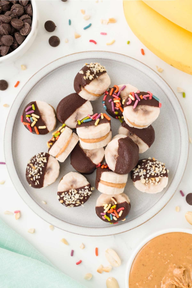 white plate filled with peanut butter bananas on a white table