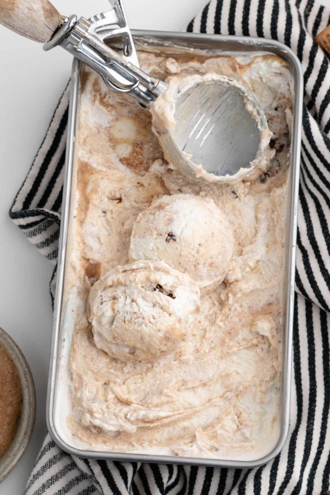 ice cream scooper in a loaf pan filled with cottage cheese ice cream