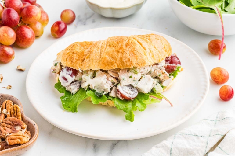 grape chicken salad in a croissant on a white plate