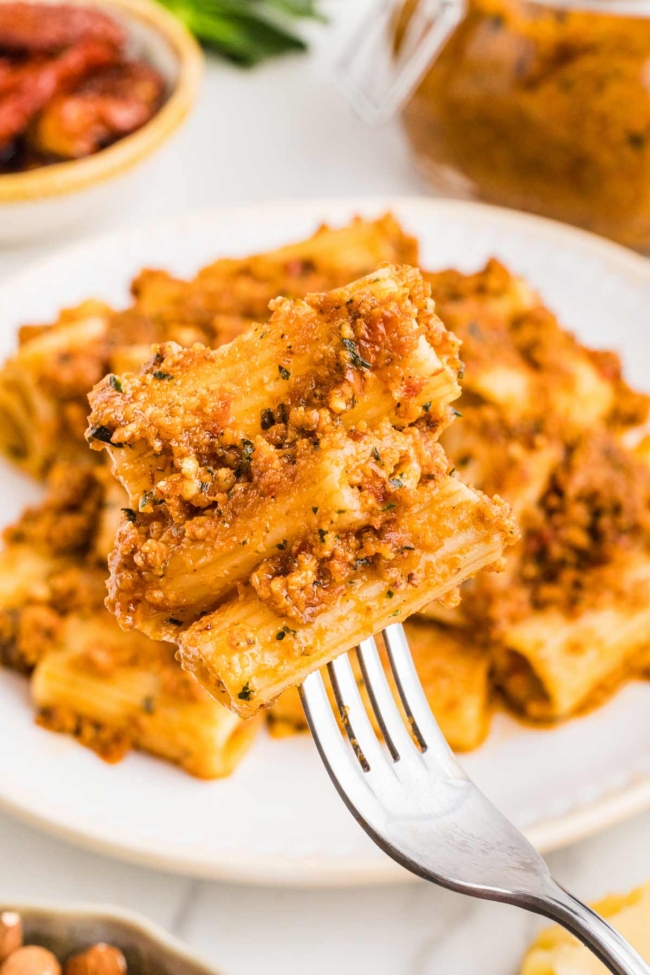 fork digging into sun-dried tomato pesto pasta