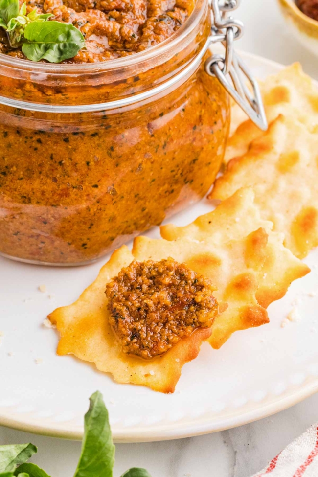 sun-dried tomato pesto on a cracker on a white plate