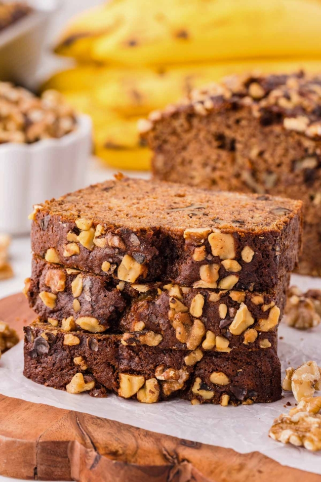 Stack of 3 whole wheat banana nut bread slices on a white plate
