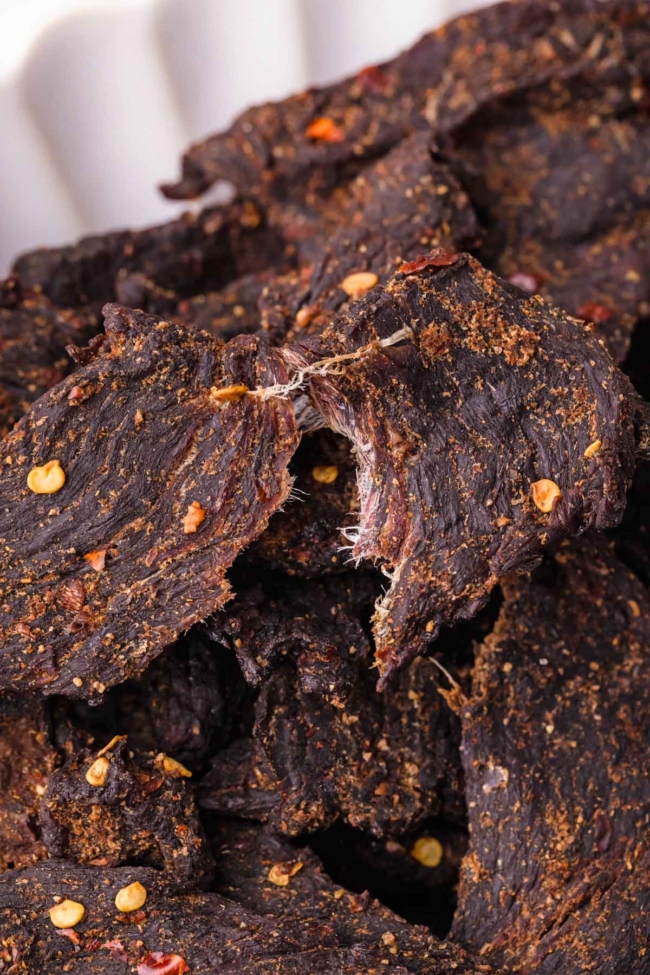 Close-up of dark, spiced venison jerky pieces, showcasing their texture and seasoning.